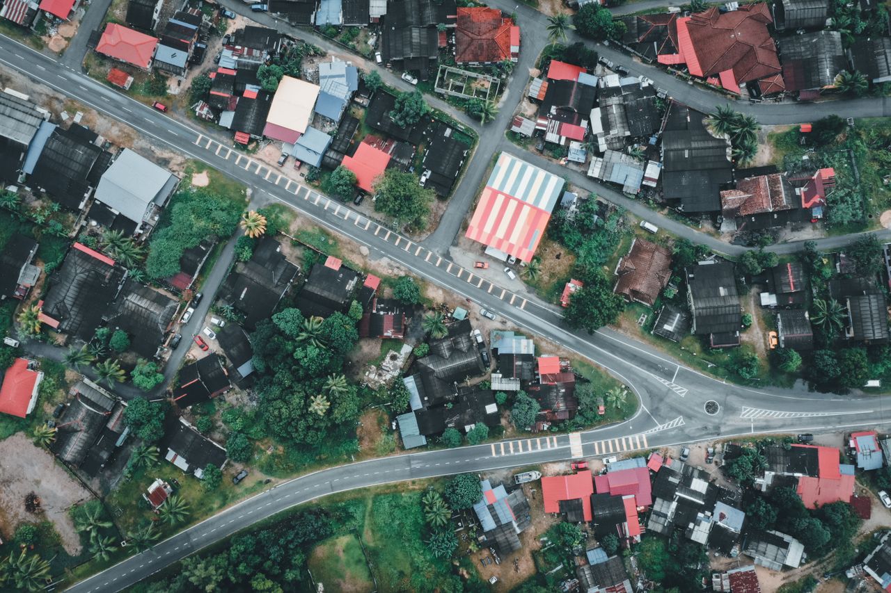 High-angle shot of residential architecture in Chukai, Terengganu, Malaysia, showcasing vibrant rooftops and lush greenery.