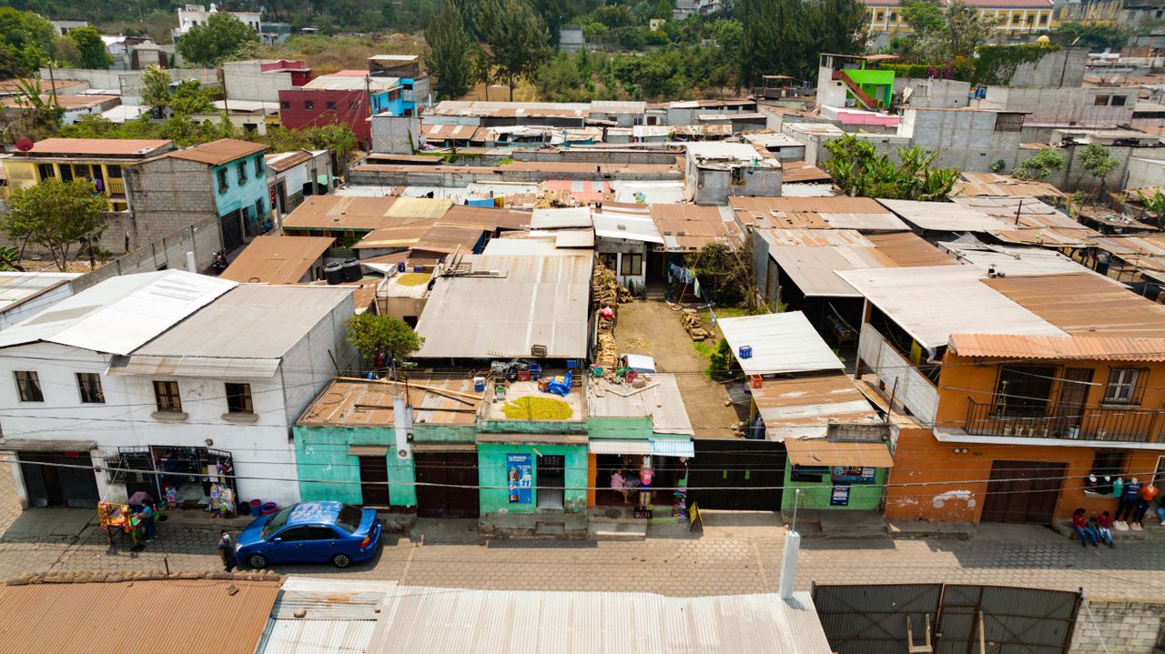 Aerial view of a diverse urban neighborhood with flat-roofed buildings and street life.