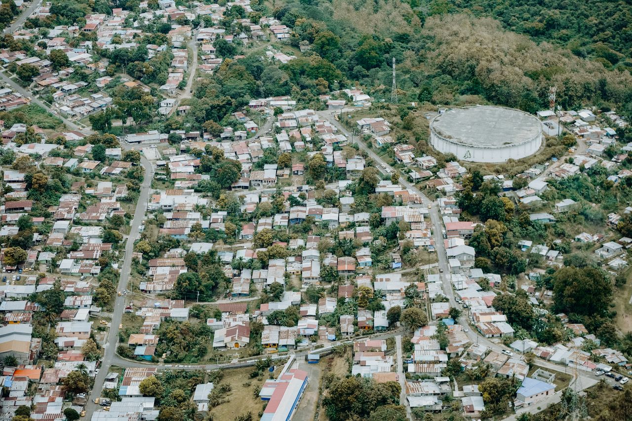Aerial view of a suburban neighborhood alongside a large reservoir and lush greenery.