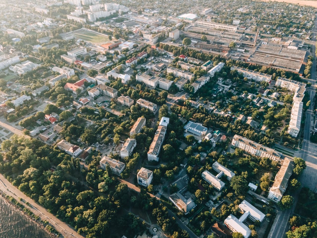 Aerial view of urban cityscape with residential buildings, roads, and greenery.